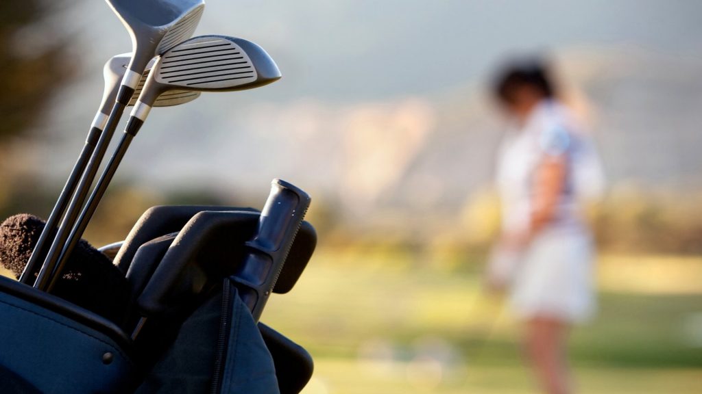 college female NIL student athlete in background of golf clubs